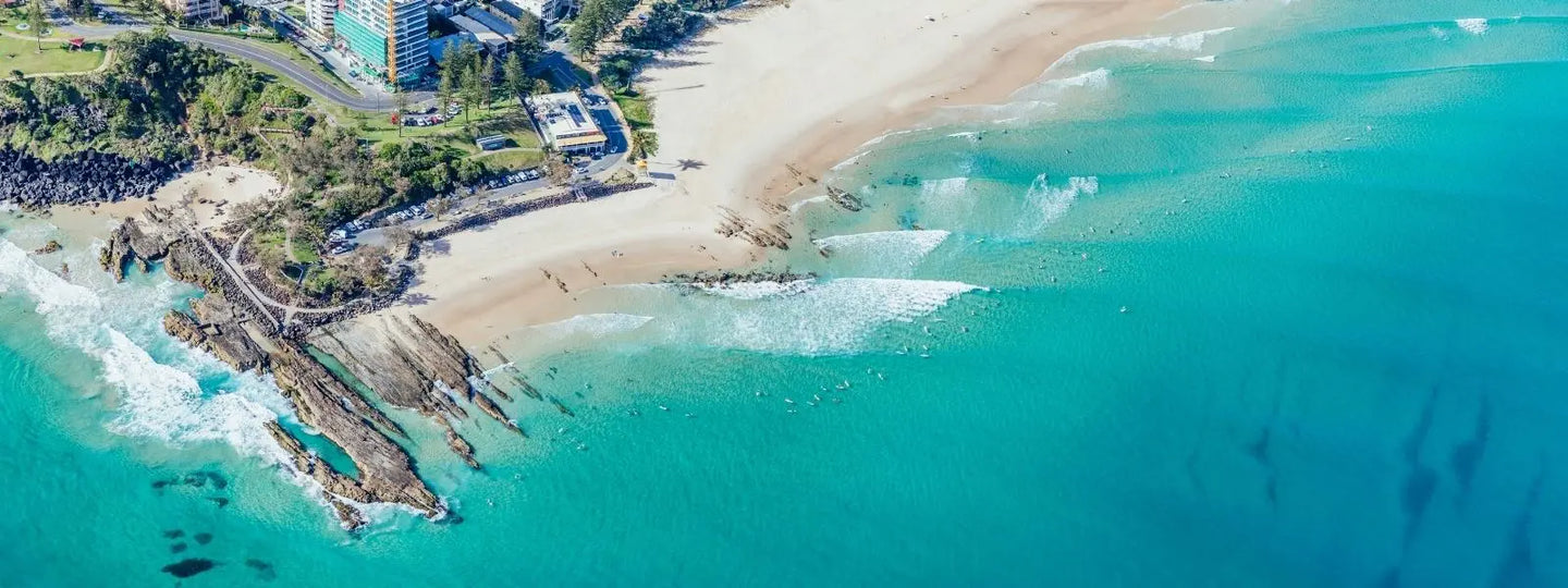 Aerial view of a beach and turquoise ocean, hero image for House of Dune’s About page.