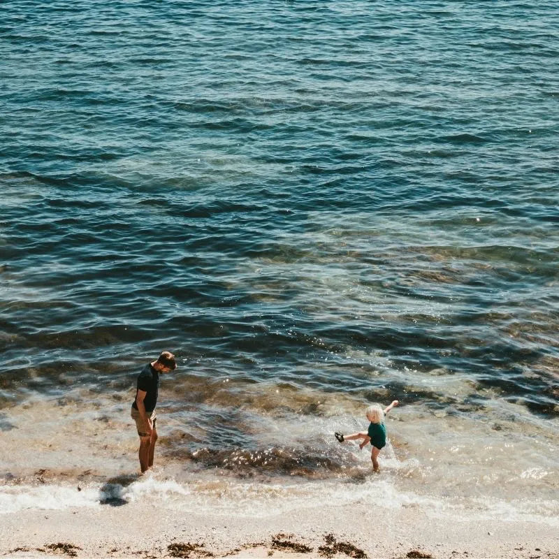 People walking along a sandy shoreline, editorial lifestyle image for House of Dune.