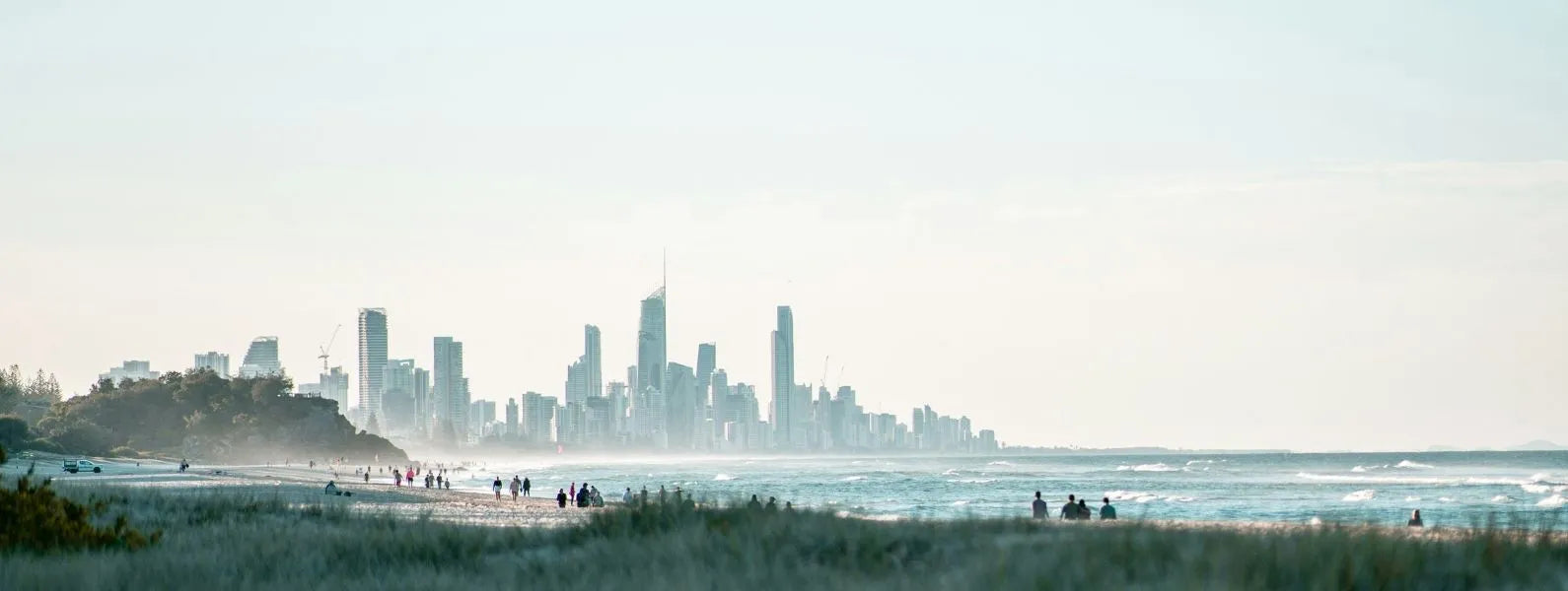 Shoreline with calm ocean and pale sand, desktop hero banner background.