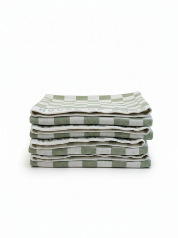 Stack of four House of Dune Salted Sage beach towels in soft green and white checkerboard design, folded for a minimal coastal look.