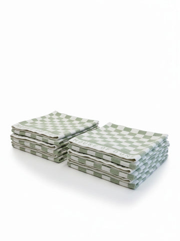 Six House of Dune Salted Sage beach towels folded in two stacks, featuring sage green and white check pattern for modern coastal style.