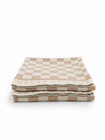 Set of two House of Dune Sand Drift beach towels with beige and white checkerboard design, neatly folded on a clean white background.