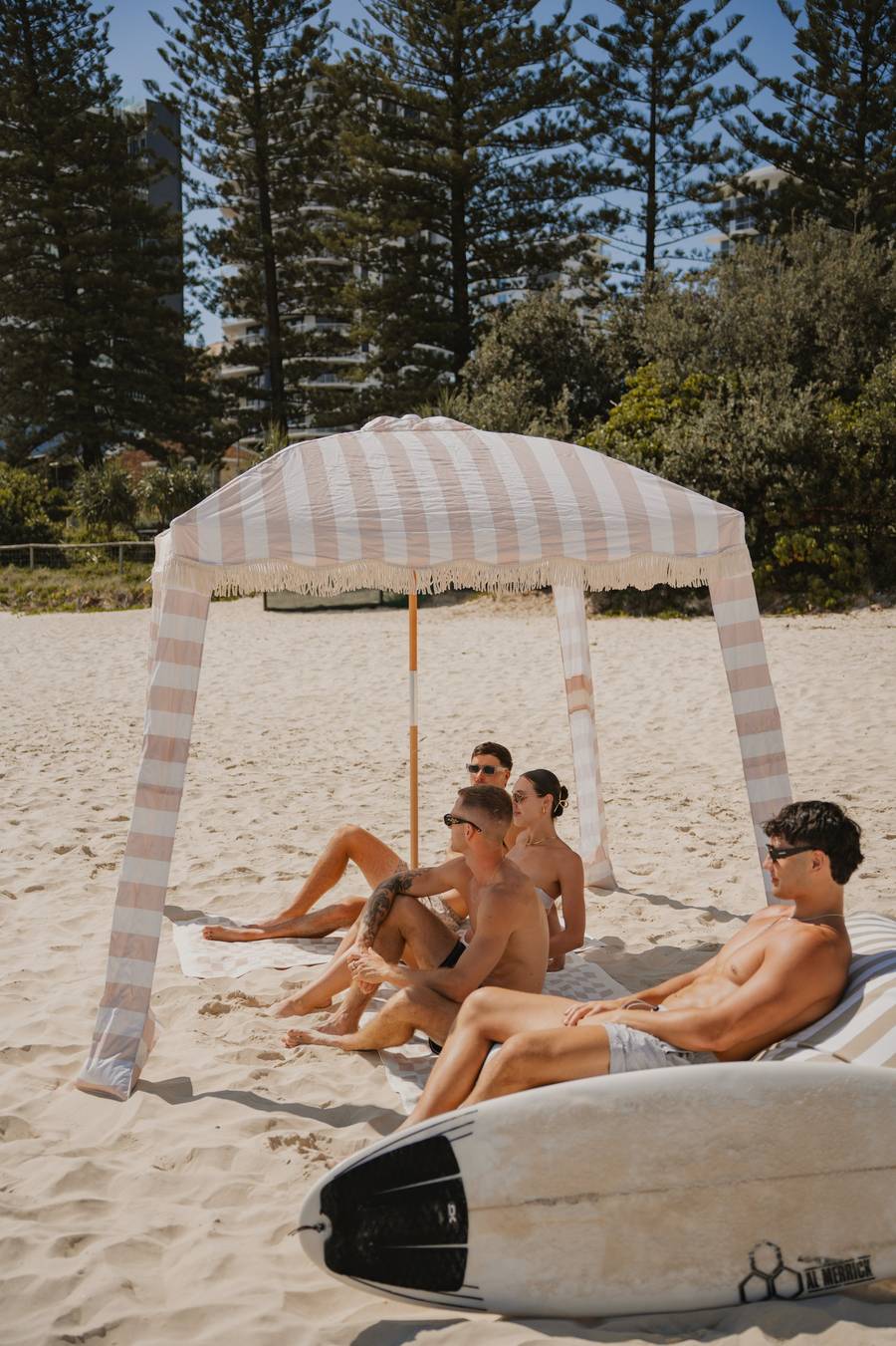 Friends relaxing under a Sand Drift Beach Cabana