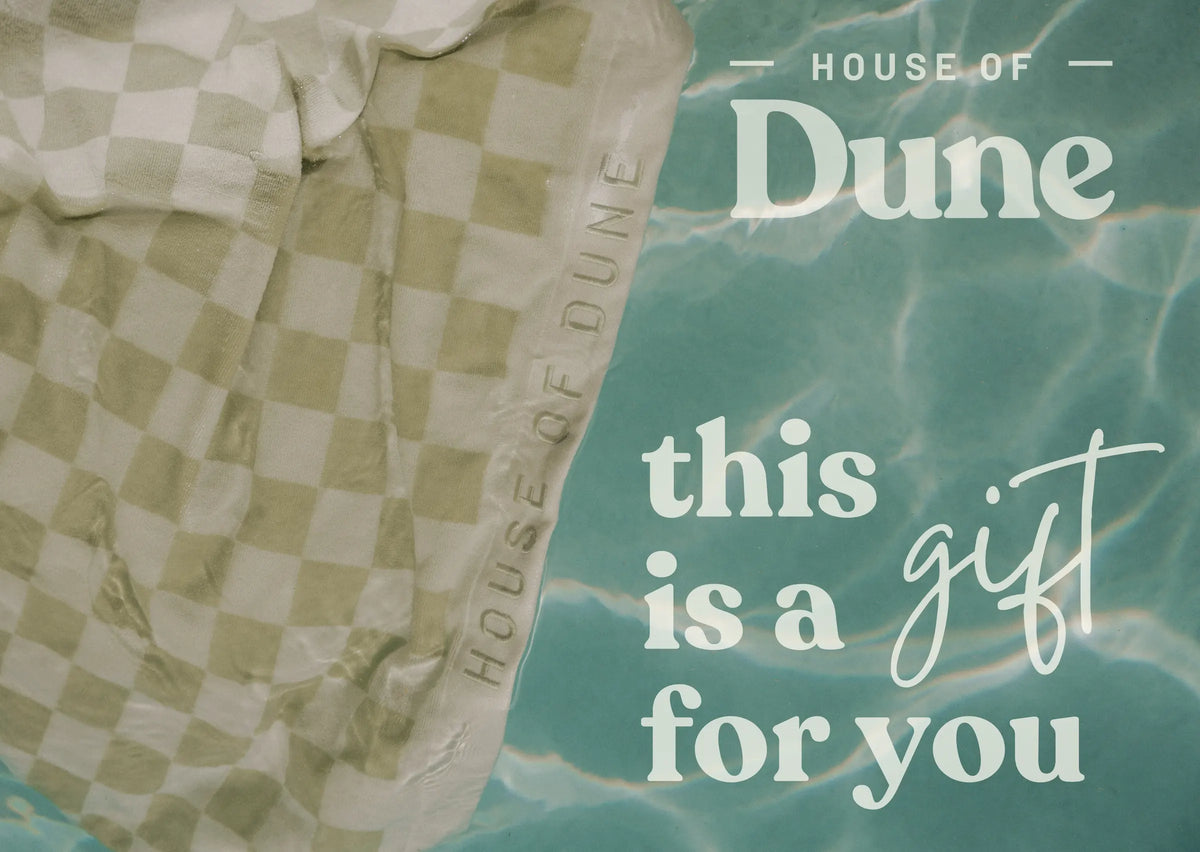 House of Dune digital gift card design featuring a sage-green and white checkered towel beside turquoise pool water with the text ‘this is a gift for you,’ representing relaxed coastal luxury and premium summer gifting