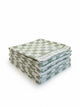 Four House of Dune Salted Sage beach towels folded and stacked, alternate angle showing the sage and white check.