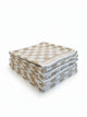 Four House of Dune Sand Drift beach towels folded and stacked, alternate angle showing the beige and white check.