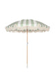 Upright Salted Sage striped beach umbrella with wooden pole and tassel fringe, designed by House of Dune.