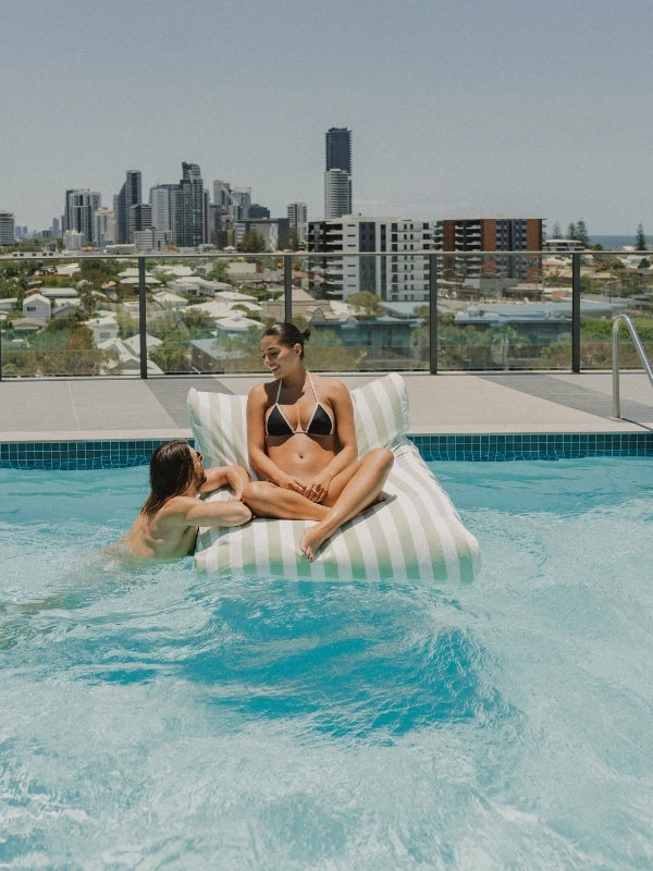 Salted Sage Floating Bean Bag Lounger by House of Dune, crafted from recycled RPET and styled poolside for relaxed social lounging with city views.