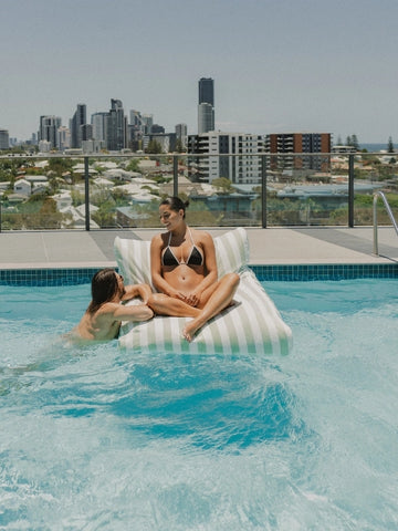 Salted Sage Floating Bean Bag Lounger by House of Dune, crafted from recycled RPET and styled poolside for relaxed social lounging with city views.