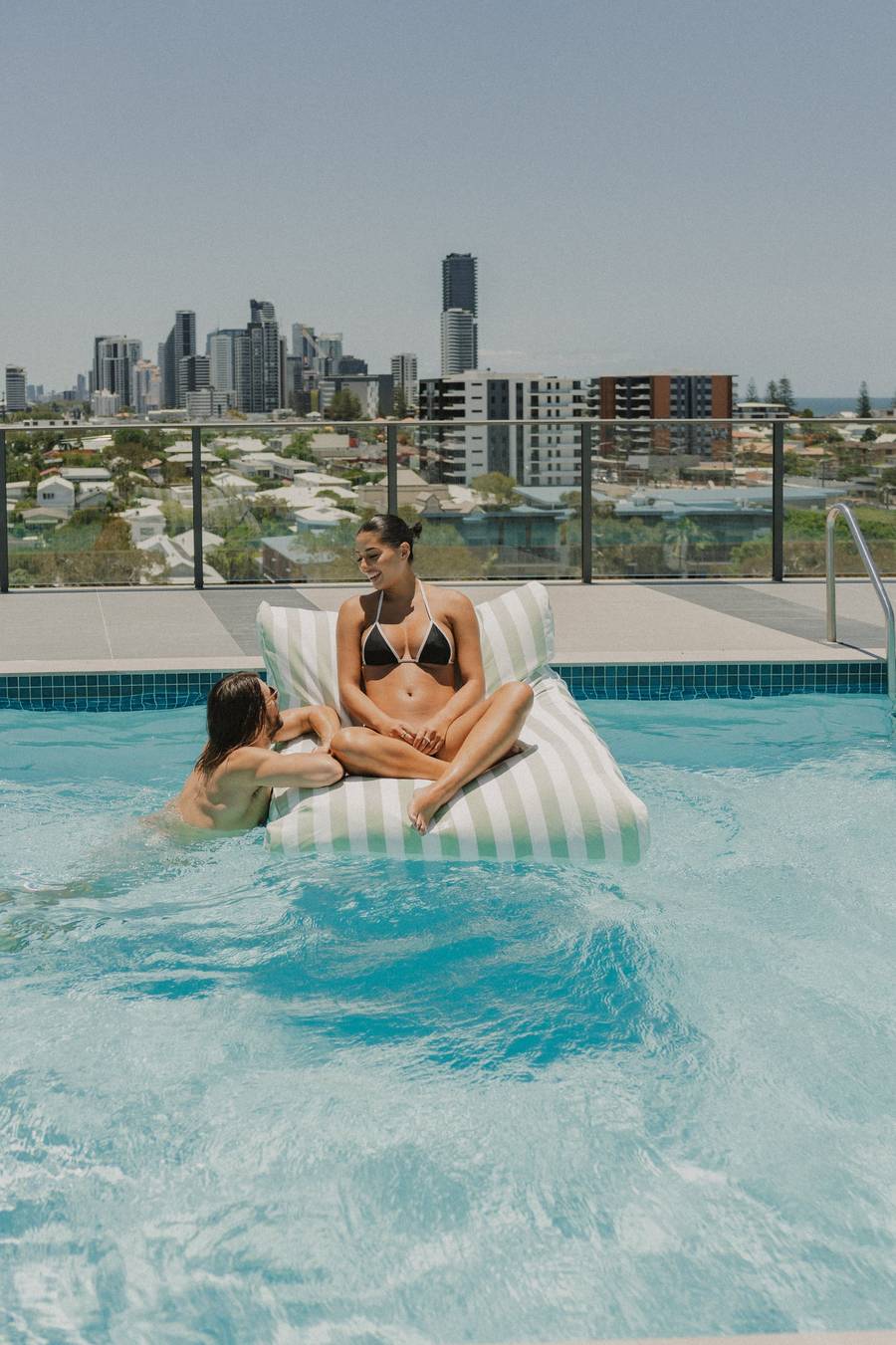 Salted Sage Floating Lounger on a city rooftop pool
