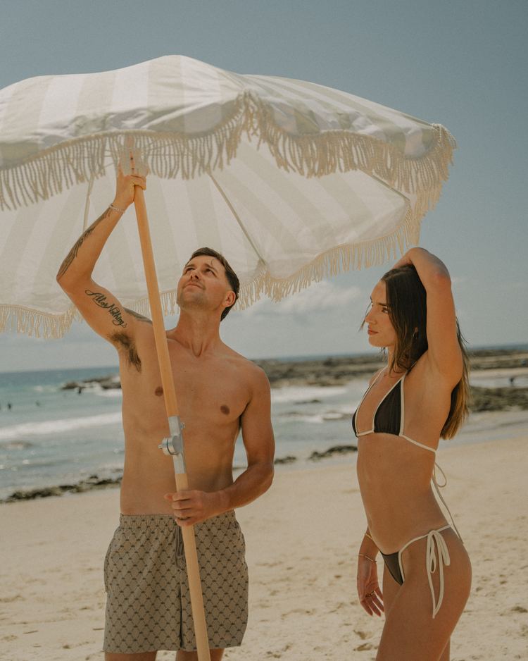 A couple opening a Beach Umbrella by the sea