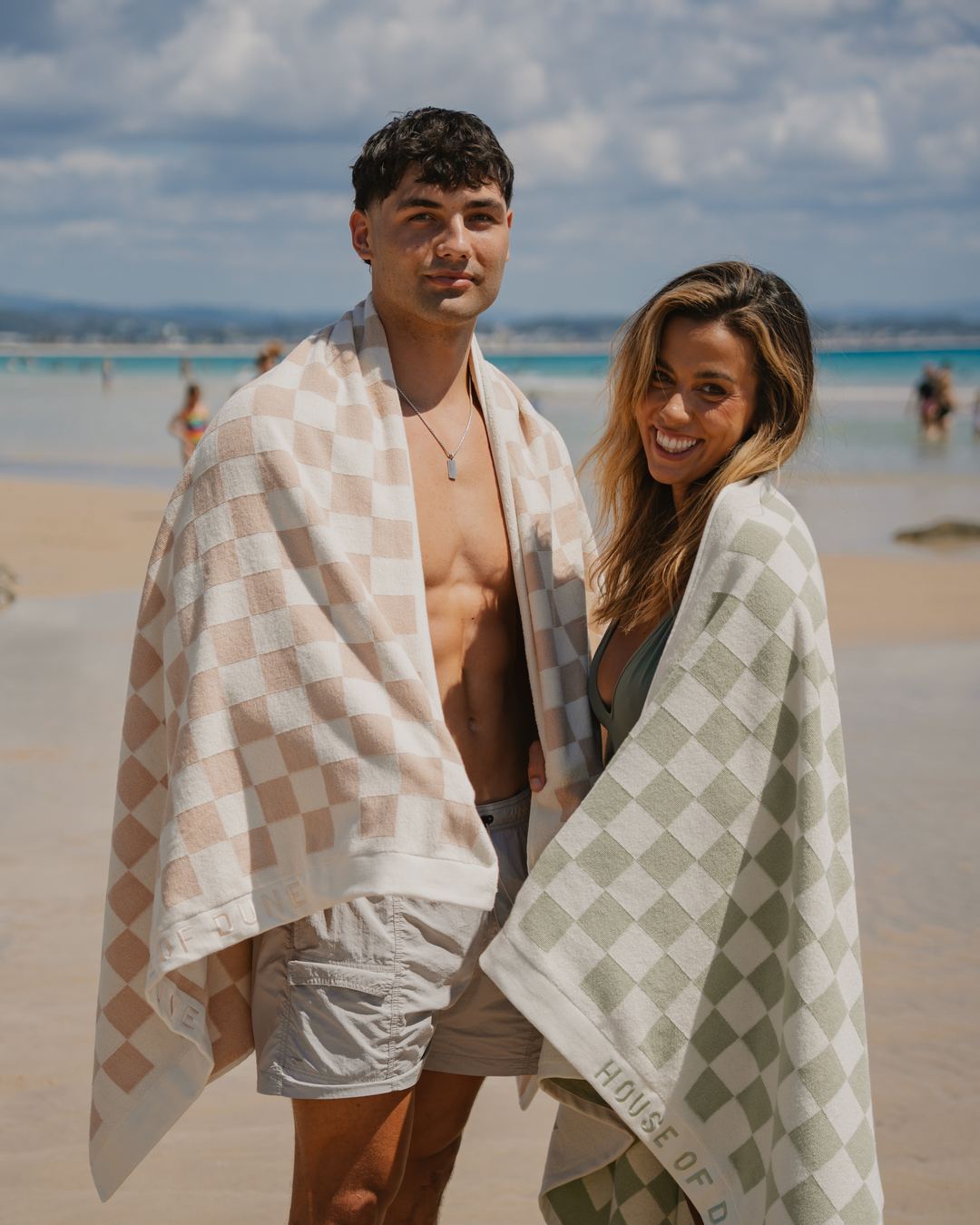 Two friends wrapped in Beach Towels in Sand Drift and Salted Sage on the beach